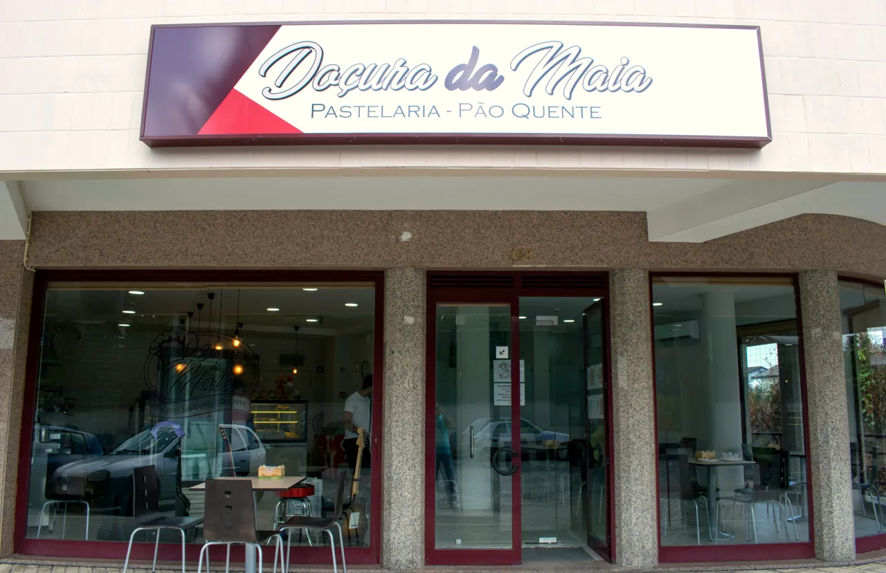 A fachada da Doçura da Maia, com a placa Pastelaria e Pão Quente por cima das montras